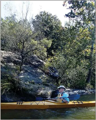  ?? NWA Democrat-Gazette/FLIP PUTTHOFF ?? Warren Cunningham explores the rocky shores of Lincoln Lake on Oct. 13 in a kayak he built himself.