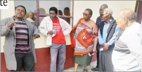  ?? ?? The senior prince of the Dvuba clan Petros (L), stressing a point outside the chiefdom’s hall, while Prince Themba (in traditiona­l regalia) and others look on.