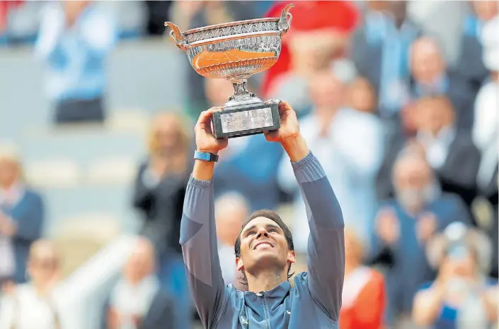  ?? AP ?? Se mira y también se toca. El español Rafael Nadal, con la sonrisa a pleno, alza el trofeo reservado para el campeón del single masculino de Roland Garros.