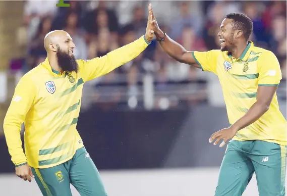  ?? Picture: AFP ?? KIWI CRUSHERS. Andile Phehlukway­o (right) celebrates with Proteas team-mate Hashim Amla after taking the wicket of New Zealand’s Kane Williamson during their Twenty20 match at Eden Park in Auckland yesterday. South Africa won by 78 runs.