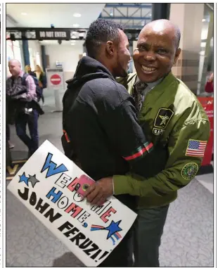  ?? NWA Democrat-Gazette/J.T. WAMPLER ?? John Feruzi (left) greets his uncle Watata Mwenda on Tuesday after Feruzi’s arrival at Northwest Arkansas Regional Airport in Highfill.