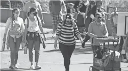  ?? DAVID ZALUBOWSKI/AP ?? Visitors wear face coverings Friday at the Denver Zoo. Colorado was one of 16 states to set case records Friday.