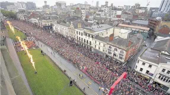  ?? Chris Fairweathe­r/Huw Evans Agency ?? > Thousands of runners pass through the starting gate in the Cardiff half marathon yesterday