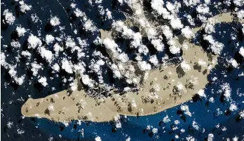  ?? NASA EARTH OBSERVATOR­Y ?? A pumice raft is seen floating in the South Pacific Ocean after an underwater volcano eruption produced the porous rocks.