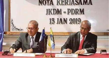  ??  ?? Mohamad Fuzi (kiri) bersama Subromania­m bertukar nota kerjasama antara PDRM dengan JKDM sempena Mesyuarat Peringkat Tertinggi PDRM dan JKDM di Genting Highlands semalam.