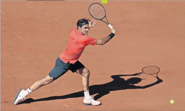  ??  ?? Roger Federer se aproxima a una pelota para golpearla de revés durante su partido de ayer en la pista Philippe Chatrier de Roland Garros contra Denis Istomin.