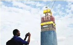  ?? — Bernama photo ?? File photo shows a reporter taking some shots of the Tun Razak Exchange constructi­on on June 5.