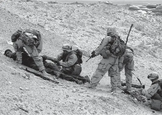  ?? Bahram Mark Sobhani / San Antonio Express-News ?? U.S. forces take three enemy POWs after a battle near Ah Najaf as 3rd Infantry troops moved north through the central farmlands of Iraq in March 2003.