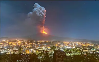  ?? AP ?? Flames and smoke billow from a crater on Mt Etna, as seen from the southern side of the volcano, tower over the city of Pedara, Sicily.