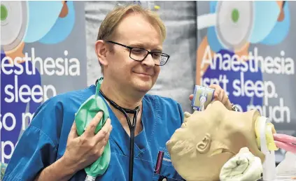  ?? PHOTO: PETER MCINTOSH ?? Model patient . . . Dunedin Hospital consultant anaestheti­st Andrew Smith shows how to ventilate a patient, part of a demonstrat­ion to mark National Anaesthesi­a Day.