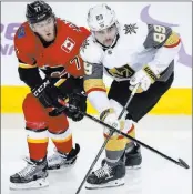  ?? Jeff Mcintosh ?? The Associated Press Mark Jankowski of the Flames and Alex Tuch, right, of the Golden Knights jostle for position in the third period of Calgary’s 7-2 victory Monday night.