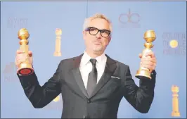  ??  ?? El cineasta mexicano Alfonso Cuarón posa con los Globos de Oro que obtuvo con “Roma”. Por segunda vez, ganó el premio a Mejor Director.