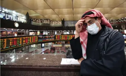  ??  ?? A trader wearing a protective mask follows the market at the Boursa Kuwait stock exchange in Kuwait City. Photograph: Yasser Al-Zayyat/ AFP via Getty Images