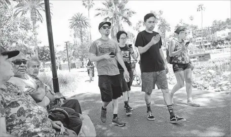  ?? Christina House For The Times ?? U.S. PLAYERS search for Pokemon in Echo Park. Some Chinese players use GPS software to pretend they are walking around L.A.