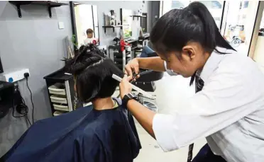  ??  ?? Form Five student Irene may not choose to pursue hairstylin­g as a career but she still enjoys learning how to cut hair at cut X Dignity.