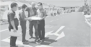  ??  ?? TURUN PADANG: Lee ditemani wakil Majlis Bandaraya Miri (MBM) ketika memeriksa keadaan projek penurapan jalan di Lembah Hijau semalam.