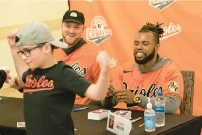  ?? HALDAN KIRSCH/FOR BALTIMORE SUN MEDIA PHOTOS ?? The Orioles’ Bryan Baker, left, and Cedric Mullins, laugh as fan T.J. Saxenmeyer shows off his Mullins shirt at the Sheraton Baltimore North in Towson on Feb. 5.