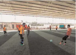  ?? — AFP ?? Syrian youths from the Damascus suburb of Qadam play against a team from Binnish ( in orange) during a football tournament in the rebel- held northern Syrian city of Idlib on August 7.