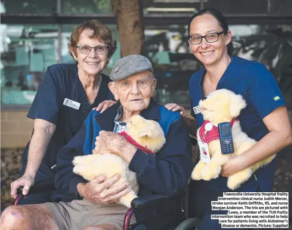  ?? ?? Townsville University Hospital frailty interventi­on clinical nurse Judith Mercer, stroke survivor Keith Griffiths, 95, and nurse Morgan Anderson. The trio are pictured with Lewy, a member of the TUH frailty interventi­on team who was recruited to help care for patients living with Alzheimer's disease or dementia. Picture: Supplied
