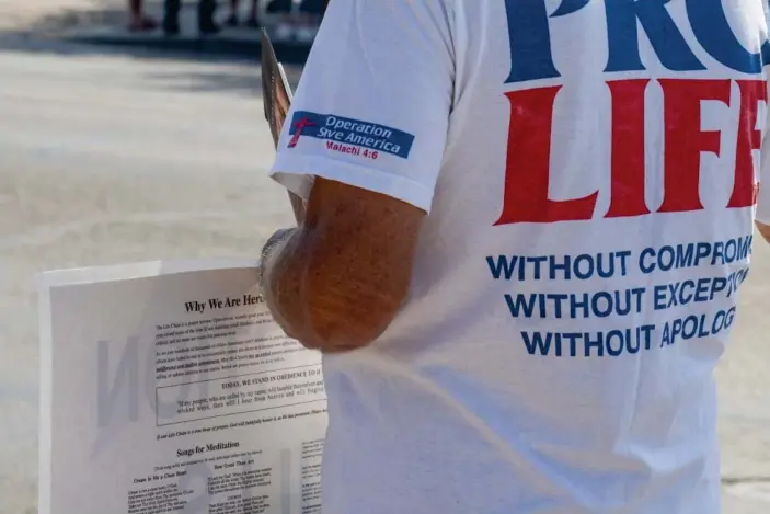  ?? Photograph: Caitlin O'Hara/The Guardian ?? A member Operation Save America protests against abortion outside Camelback Family Planning in Phoenix on 24 June.