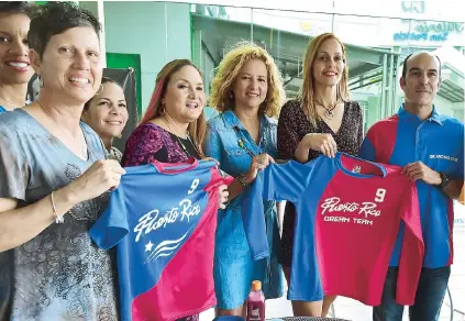  ??  ?? Sara Rosario (centro) y el Dr. Michael Soler, hacen entrega del uniforme a algunas jugadoras que representa­rán a Puerto Rico en Costa Rica del 23 al 30 de abril.