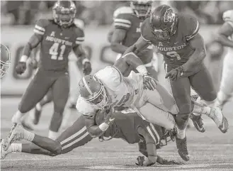  ?? Michael Ciaglo / Houston Chronicle ?? UH linebacker Matthew Adams, right, here getting in on the action against Tulane last year, is projected as a vocal leader, team captain material and “rock of the defense” entering this season.