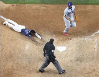  ?? MAXX WOLFSON/GETTY IMAGES ?? The Rays’ Randy Arozarena dives into home plate to score the winning run on an error in the ninth inning Saturday against the Dodgers in Game 4 of the World Series in Arlington, Texas.