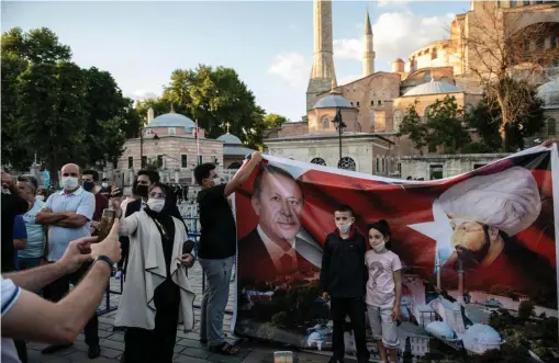  ??  ?? Partisans. Le 10 juillet, devant Sainte-Sophie, des habitants d’Istanbul affichent leur soutien au président Erdogan, ici associé à l’image de Mehmed, « le Conquérant ».