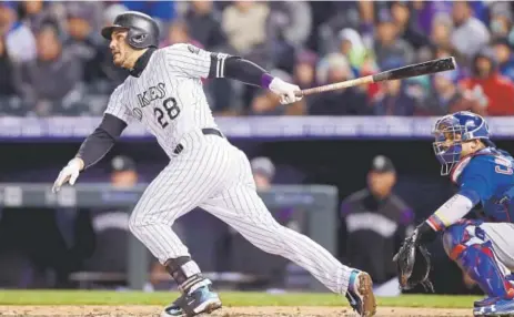  ?? Getty Images ?? The Rockies’ Nolan Arenado hits an RBI single in the fifth inning against the Chicago Cubs at Coors Field on Saturday night.