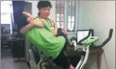  ??  ?? Guan Ping lifts Liguan onto an exercise machine in their home.