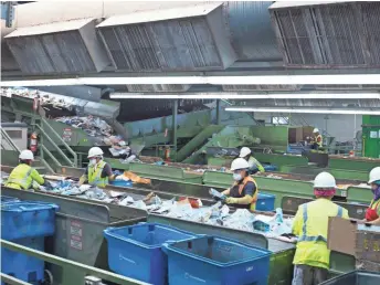  ??  ?? Workers at a Phoenix facility sourt through recycled goods in June. A Chinese crackdown on imports of “foreign garbage” is affecting Valley cities’ exports of recyclable materials.