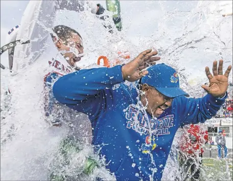  ?? Steph Chambers/Post-Gazette photos ?? Jeannette’s Anthony Johnson, left, douses coach Roy Hall with water after the Jayhawks beat Homer-Center, 42-12, to claim the PIAA Class A title Thursday at Hersheypar­k Stadium in Hershey, Pa.