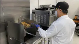  ?? TERRY CHEA — THE ASSOCIATED PRESS ?? Nathan Foot, R&D chef at Impossible Foods, takes its new meatless nuggets out of a deep fryer in the company’s test kitchen on Sept. 21in Redwood City. The plant-based nuggets taste are designed to taste like chicken.