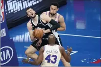  ?? MATT SLOCUM - THE ASSOCIATED PRESS ?? Los Angeles Clippers’ Ivica Zubac center, tries to pass between the Sixers’ Ben Simmons, top, and Anthony Tolliver during the second half of a game on April 16 at Wells Fargo Center.