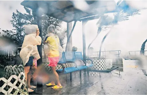  ??  ?? In Hong Kong, the storm alert for Typhoon Mangkhut was raised to its highest level. A child was rescued from a collapsed school, above left, as winds tore through the city, above