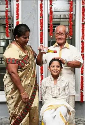  ??  ?? Adapt and respect: Leong happily participat­es in Deepavali traditions such as giving his grandson Cong Min an oil bath. Looking on is Valiamah.