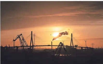  ?? FOTO: CHRISTIAN CHARISIUS/DPA-TMN ?? Hafenroman­tik: Die Sonne geht hinter der Köhlbrandb­rücke unter.