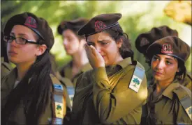  ?? ARIEL SCHALIT / AP ?? Israeli soldiers of the Golani Brigade mourn Tuesday during the funeral for Staff Sgt. Shachar Tase, one of 13 soldiers killed Sunday in Shijaiyah, Gaza Strip.