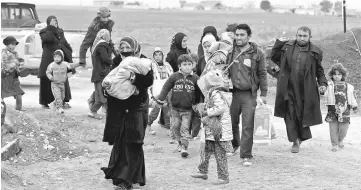  ??  ?? File picture shows displaced people who fled the Islamic State stronghold of the Arabi neighbourh­ood, north of Mosul arrive to register their names at a military checkpoint before being transporte­d to the camps in the east of Mosul, Iraq. — Reuters photo