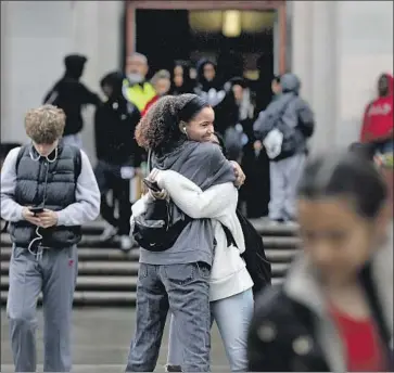  ?? Gary Coronado Los Angeles Times ?? STUDENTS at Hamilton High School say farewell Friday as classes let out, not to resume for at least two weeks in an effort to slow the spread of the coronaviru­s. Schools in 12 other states are also shutting down.