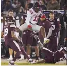  ?? AP photo ?? Mississipp­i wide receiver Dontario Drummond leaps over fallen Mississipp­i State safety Jalen Green for a first down during the first half of the Rebels’ 31-21 win over the Bulldogs on Thursday.