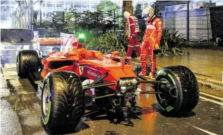  ?? BILD: SN/DIENER/EXTRA ?? Sebastian Vettel begutachte­t nach dem frühen Aus in Singapur seinen zerstörten Ferrari.