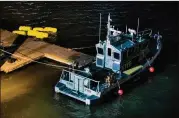  ?? ANDRES KUDACKI / AP ?? Yellow buoys that a New York police officer said are suspending a helicopter that crashed into the East River float next to an NYPD police boat at a pier in New York on Sunday. The helicopter crashed into New York City’s East River Sunday night,...