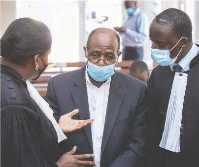  ?? AFP VIA GETTY IMAGES ?? “Hotel Rwanda” hero Paul Rusesabagi­na, centre, speaks with his lawyers at court in Kigali, Rwanda, on Sept. 17, weeks after his arrest under mysterious circumstan­ces. There's a call for Prime Minister Justin Trudeau to intercede in the case.