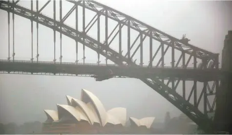  ?? Reuters ?? The Sydney Opera House is seen as strong winds and heavy rain hit the city yesterday. The storm struck only hours before the morning peak hour, transformi­ng some streets into fast-flowing rivers and parks into lakes.