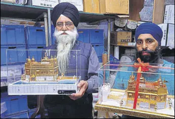  ?? SAMEER SEHGAL/HT ?? Factory owners Avtar Singh and Bhupinder Singh showing models of Golden Temple at their workshop where the miniatures are made in several sizes and with features such as music players and lighting effects, in Amritsar on Monday.