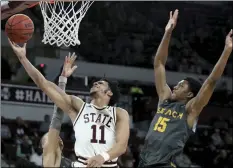  ?? AP PHOTO/JIM LYTLE ?? Mississipp­i State guard Quinndary Weatherspo­on (11) drives to the basket between Long Beach State guards Ron Freeman and Deishuan Booker (15) during the first half of an NCAA college basketball game on Friday, in Starkville, Miss.