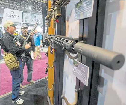  ?? REUTERS ?? Feria. Dos potenciale­s compradore­s ante un rifle Remington exhibido en el Shot Show de Las Vegas.