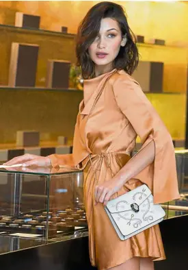  ??  ?? Bella Hadid carries the Serpenti Forever flap studded Pop Heart bag in white agate.