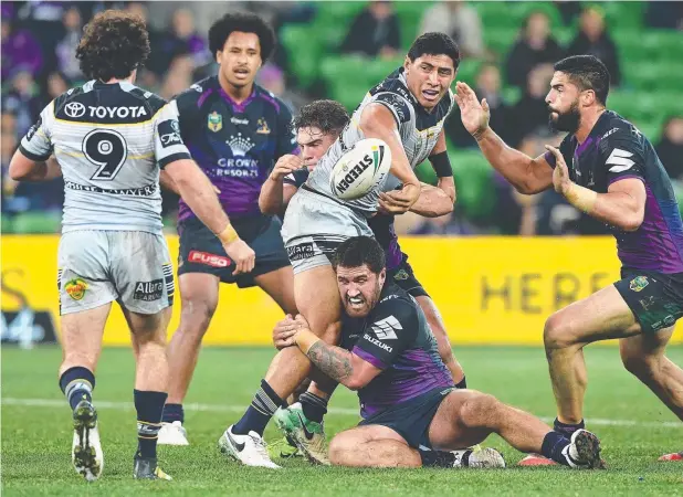  ?? Picture: GETTY IMAGES ?? POWERHOUSE: Jason Taumalolo of the Cowboys passes the ball as he’s tackled during the Round 15 clash against the Storm in Melbourne.